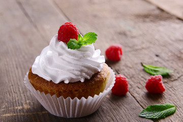 Delicious cupcake with berries and fresh mint on wooden table close up