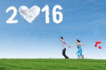 Couple running at field with numbers 2016