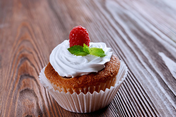 Delicious cupcake with berries and fresh mint on wooden table close up