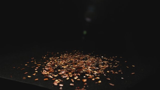 Camera follows spices flying after being exploded against white background. Slow Motion. Shot with high speed camera, phantom flex 4K.  Slow Motion. Unedited version is included at the end of clip.