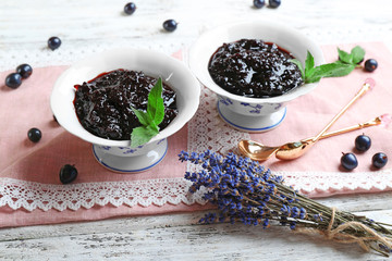Fototapeta na wymiar Tasty currant jam with berries on table close up