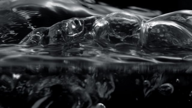Camera follows water bubbles rising on surface . Shot with high speed camera, phantom flex 4K.  Slow Motion. 