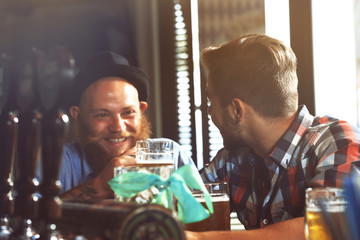 Young men drinking beer in pub