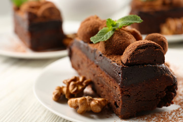 Piece of chocolate cake with walnut and mint on the table, close-up
