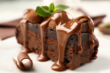 A piece of chocolate cake with mint on the table, close-up