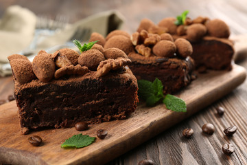Pieces of chocolate cake with walnut and mint on the table, close-up