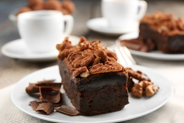 A piece of chocolate cake with walnut on the table, close-up