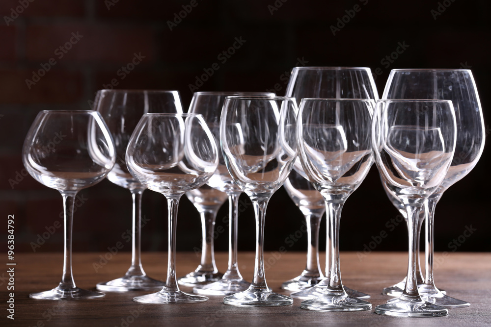 Wall mural empty wine glasses on a table on a brick wall background