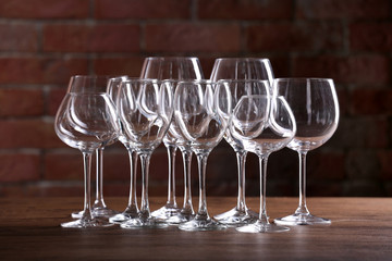 Empty wine glasses on a table on a brick wall background