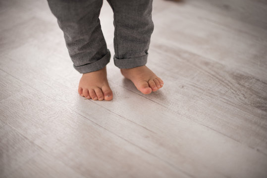 Photo feet of a little boy who goes on the floor