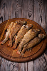 Fried fish lying on the Boards on the wooden table