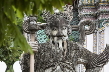 Fototapeta na wymiar Statue of a Chinese warrior near an entrance of Wat Pho. Wat Pho