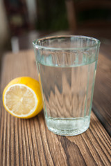 A glass of water is on the table, and next is the big fresh lemon