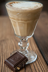 Beautiful glass with a latte and a piece of chocolate