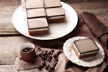 Delicious chocolate brownies on plate, on wooden background