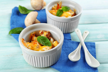 French dish julienne. Mushroom, chicken and cheese gratin in ceramic bowls, on wooden background