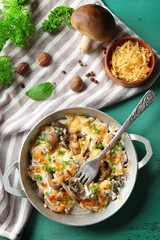 Roasted mushrooms, chicken and cheese gratin in pan, on color wooden background