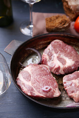 Marbled beef steak on pan and spices on color wooden background