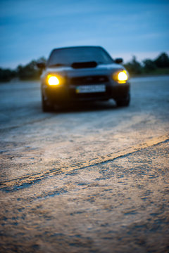 The black car headlights on the road