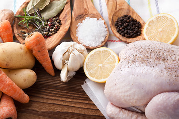 Whole raw chicken with vegetables and pepper
