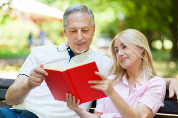 Couple reading a book in the park