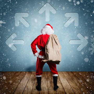 Weihnachtsmann steht vor Wand mit Pfeilen in viele Richtungen