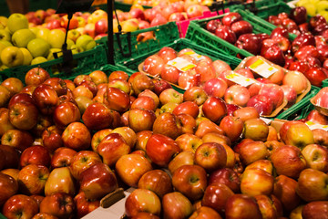 Bunch of red and green apples on boxes in supermarket