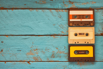 Cassette tapes over blue textured wooden table . top view. retro filter
