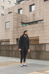 Handsome Indian man listening to music in an urban context