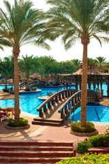Naklejka na ściany i meble Beautiful resort place - swimming pool with tropical palm garden