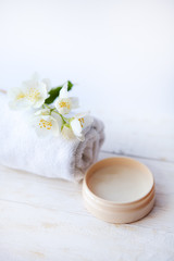 Fototapeta na wymiar beauty treatment , jasmin flowers and cosmetics on white wooden table