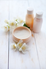 Obraz na płótnie Canvas Spa products. beauty cream and white jasmine flower on white wooden table
