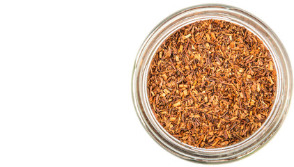 Dried rooibos herbal tea leaves in mason jar over white background