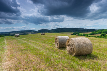 Straw bales on the stubble field in Beskid Niski mountains - obrazy, fototapety, plakaty