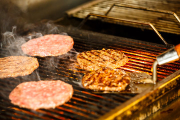 Burgers are grilled over an open fire