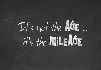 humorous quote about aging on dusty black chalkboard