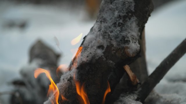 Burning logs in fire pit outside with snow background. Shot with high speed camera, phantom flex 4K.  Slow Motion. 