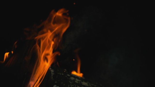 Burning logs in fire pit outside at night time. Shot with high speed camera, phantom flex 4K.  Slow Motion. 