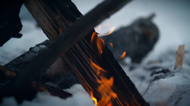Burning logs in fire pit outside with snow background. Shot with high speed camera, phantom flex 4K.  Slow Motion. 