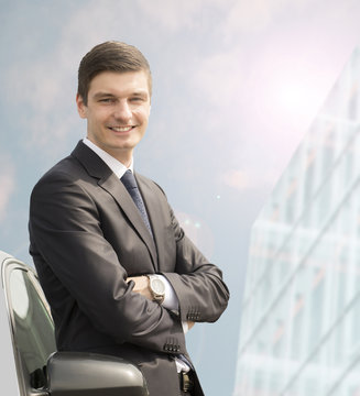 Young businessman standing near his car
