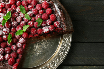 Cake with Chocolate Glaze and raspberries on tray on dark background