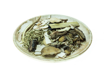 Mix of chinese herbal medicine in wooden dish isolated on white