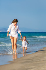 Naklejka premium Mother and daughter walking on the beach