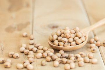 Soy beans in spoon on wooden desk