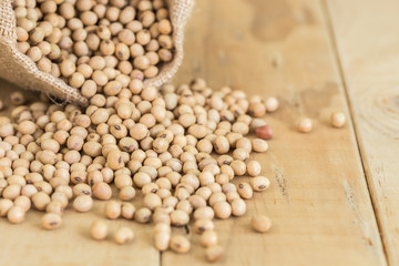 Soy beans in sack on wooden desk