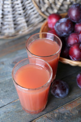 Delicious plum juice with fruits on wooden table close up