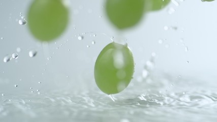 Green grapes falling and bouncing on water surface. Shot with high speed camera, phantom flex 4K. Slow Motion. - Powered by Adobe