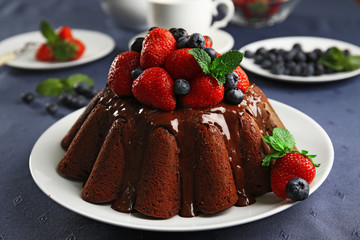 Delicious chocolate cake with strawberries in plate on table, closeup