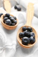 Fresh blueberries in spoons on table close up