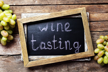 old chalk scripted frame with grape on wooden background